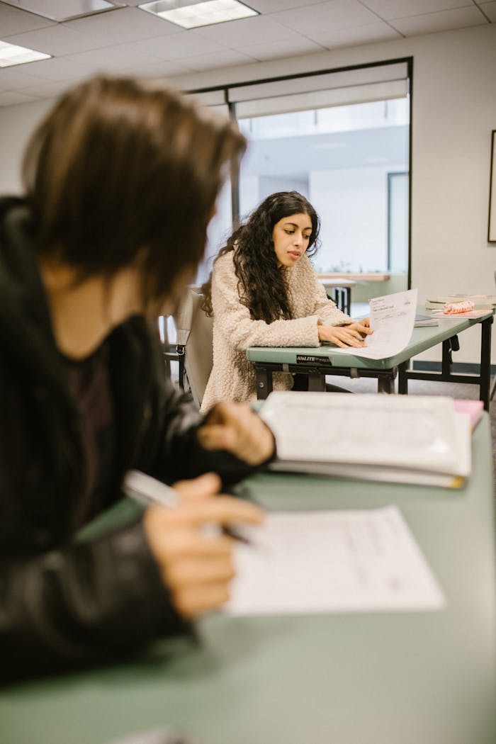 Students engaged in work during a classroom session, focusing on exams.